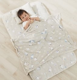 シマエナガ柄のタオルケットを使用している赤ちゃんの画像。