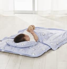 シマエナガ柄のタオルケットを使用している赤ちゃんの画像。