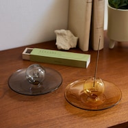 落ちる灰を受け止めるガラスの香立て