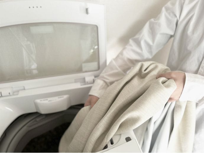 洗濯機にカーテンを入れるイメージ