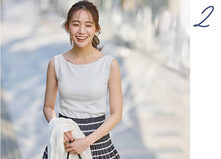 ブラトップボートネックノースリーブを着た女性の画像。きちんと感漂うボートネックは ボレロと合わせても。夏のきれいめ洗練スタイルに。