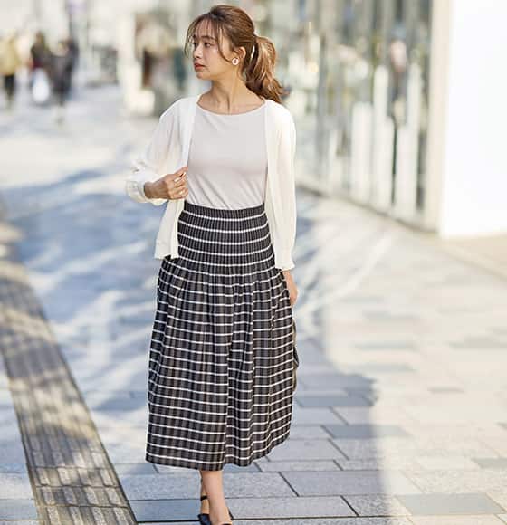 ブラトップボートネックノースリーブを着た女性の画像。きちんと感漂うボートネックは ボレロと合わせても。夏のきれいめ洗練スタイルに。