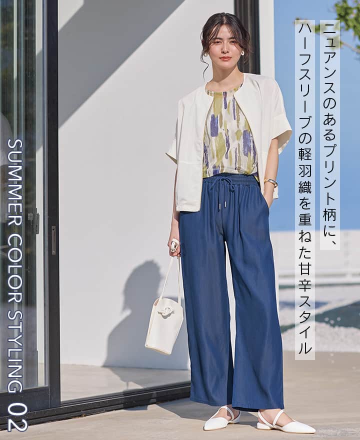 ブルー×イエローのコーディネートの女性の画像。ニュアンスのあるプリント柄に、ハーフスリーブの軽羽織を重ねた甘辛スタイル