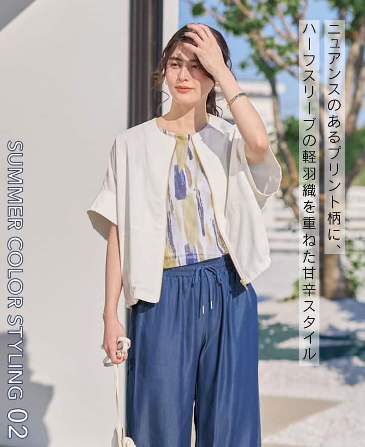 ブルー×イエローのコーディネートの女性の画像。ニュアンスのあるプリント柄に、ハーフスリーブの軽羽織を重ねた甘辛スタイル