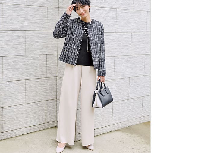 ツイードジャケットを着た女性の画像。華やかジャケットは、ジャージー素材のパンツで抜け感をプラス